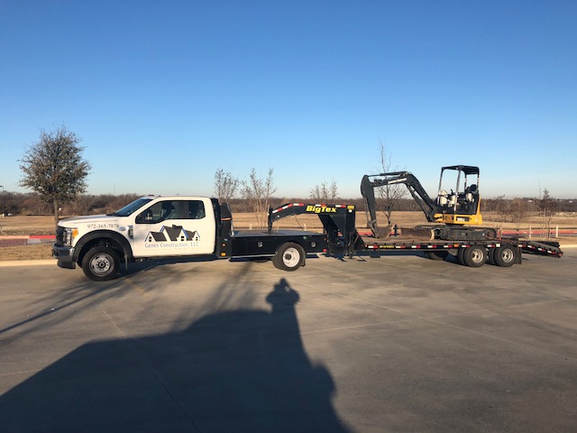 Genes Construction roofing truck hauling a mini excavator for tear-off, site work, and roof replacement staging