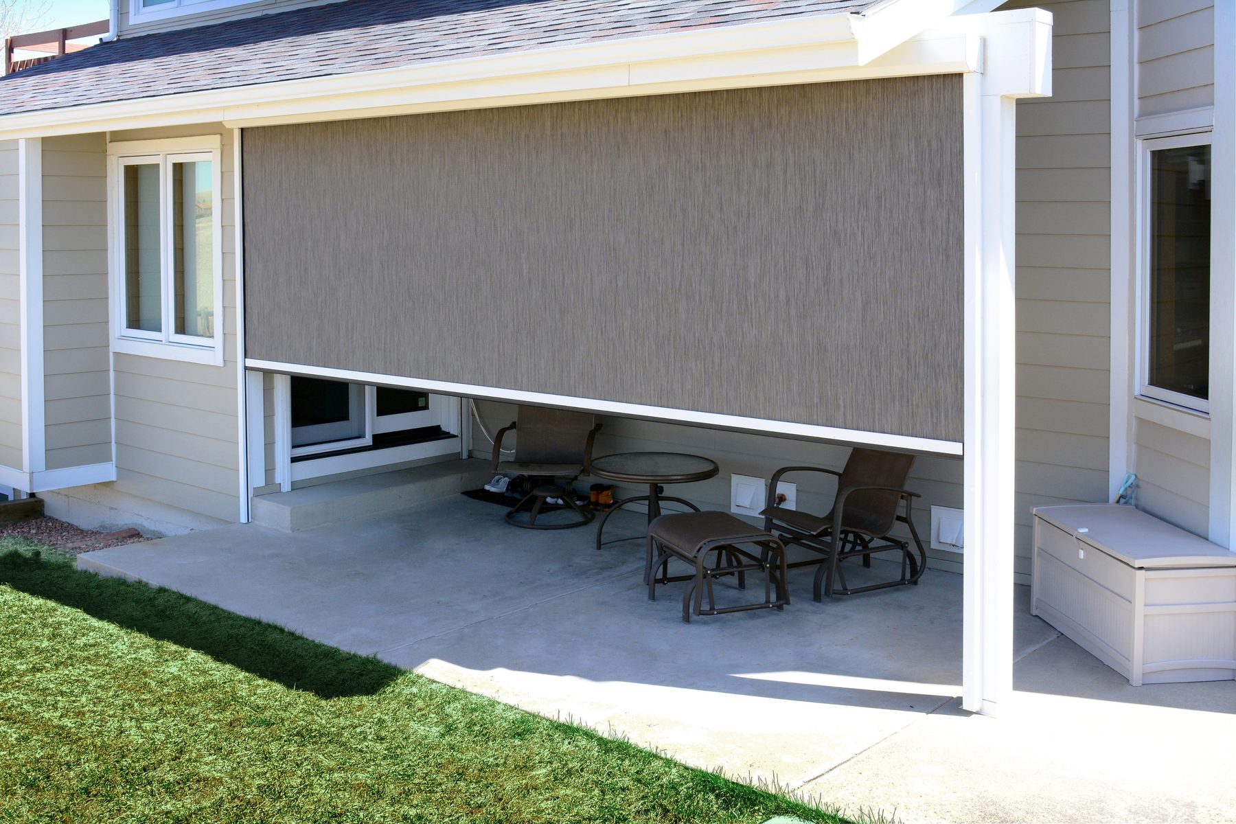 Exterior drop roller shade shading a covered patio on a North Texas home in the Frisco and Prosper area