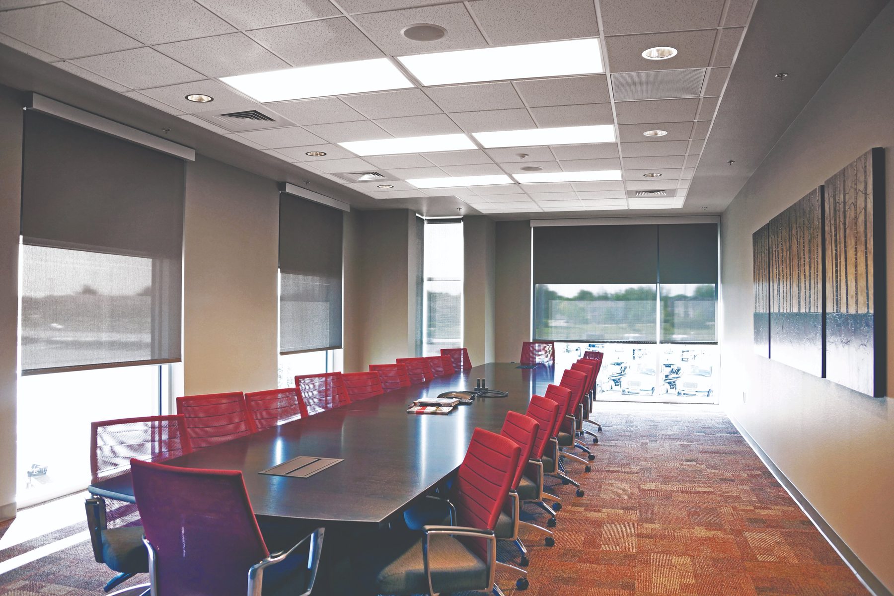 Roller shades on a boardroom window wall, some open and some lowered, for meetings in Frisco commercial space