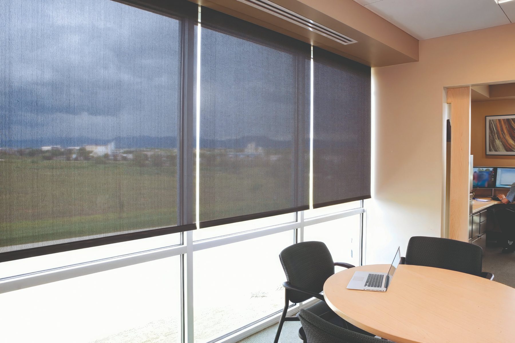 Interior solar shades on a conference-room window wall, cutting glare for a Frisco or Prosper office without blocking the view