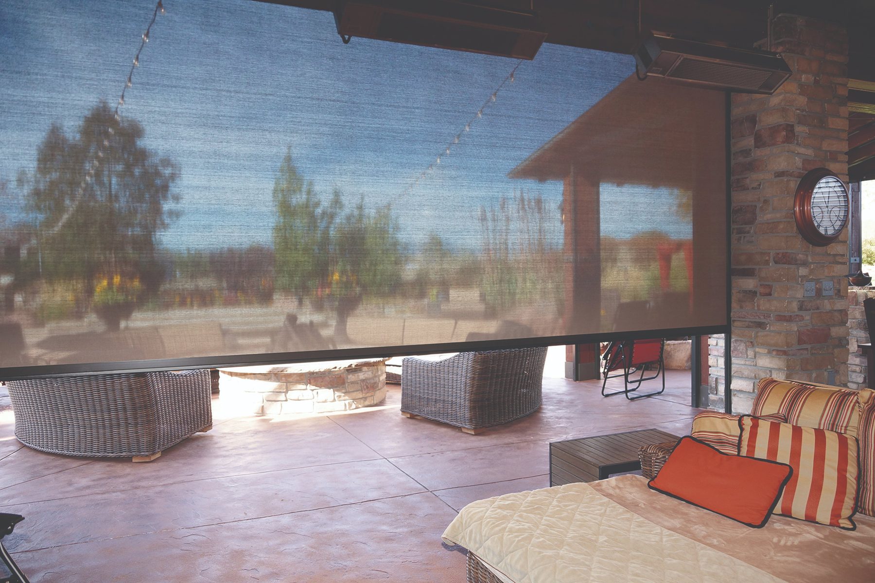 Large exterior roller shade dropped over a lounge patio to block afternoon sun in a North Texas outdoor living space