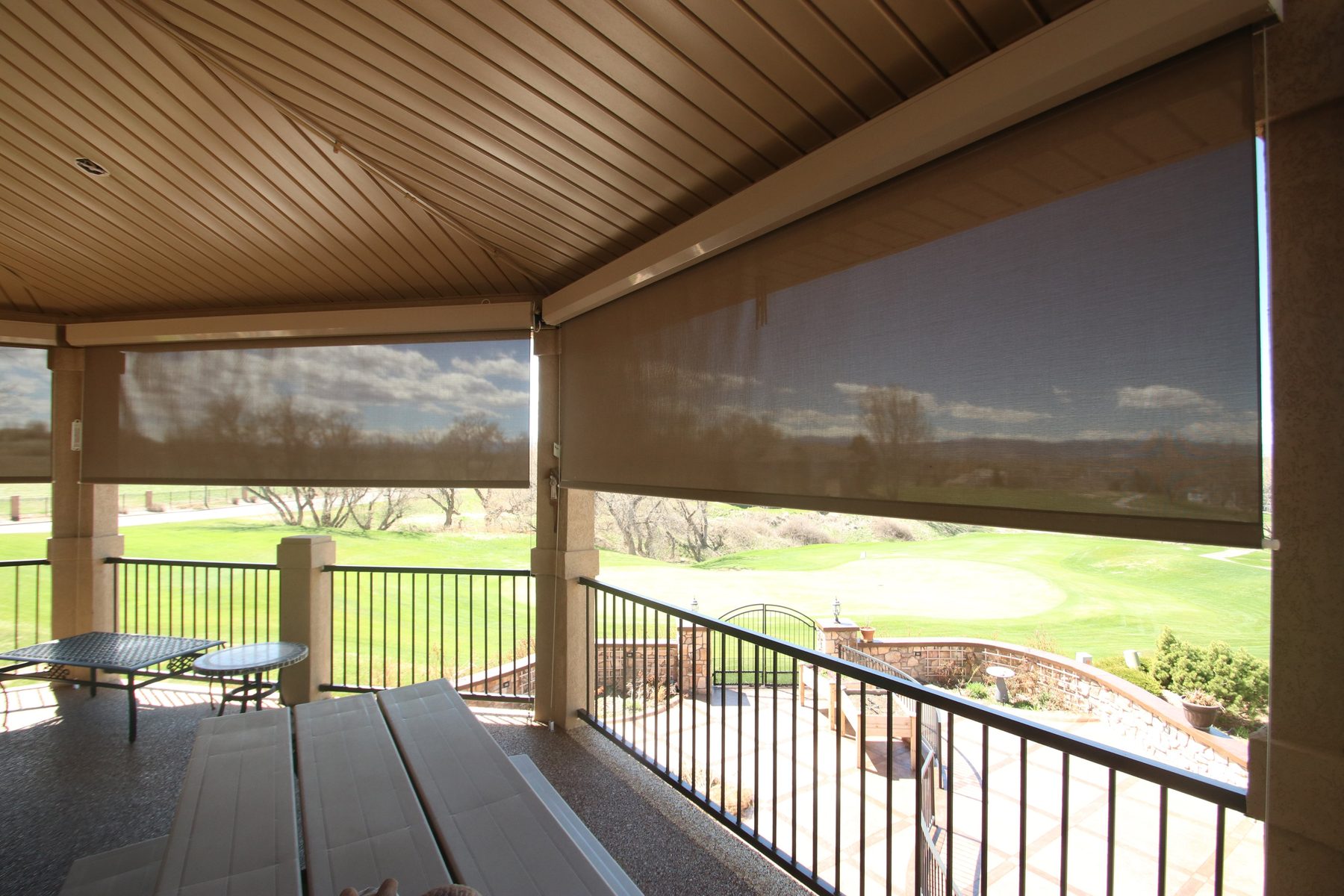 Large solar-screen exterior shades on a covered porch overlooking a lawn, specified for west sun in Frisco and Prosper
